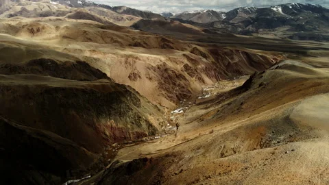 A huge mountain range of brown color. Shadows from the clouds give volume to the Stock Footage 195624188
