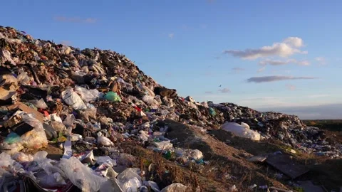 Huge mountains of discarded refuse and various plastic items rise under a b.. Video stock 321918145