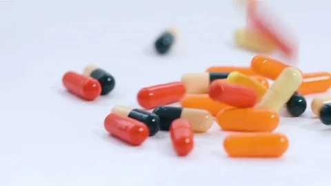 A huge number of pills falling on white background top view in slow motion. Stock Footage 72846546