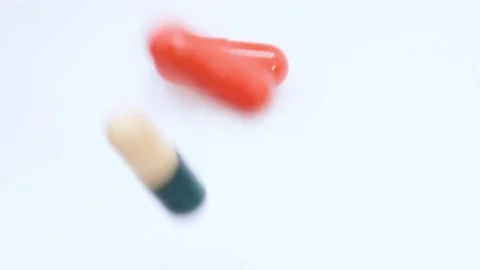 A huge number of pills falling on white background top view in slow motion. Stock Footage 73034444