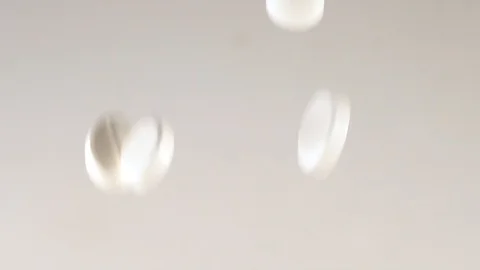 Huge number of white pills falling slow motion.Macro Stock Footage 127621771