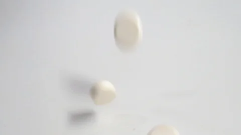 Huge number of white pills falling on white background  slow motion.Macro Stock Footage 127621906