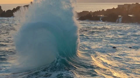Huge ocean wave rises and crashes near black lava rocks in Porto Moniz Stock Footage 341755138