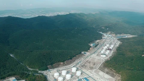A huge oil refining and storage plant surrounded by mountains Stock Footage 128548892