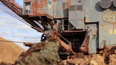 A huge, old dragline turns, doing its job. Mining excavator close-up Stock Footage 123572070