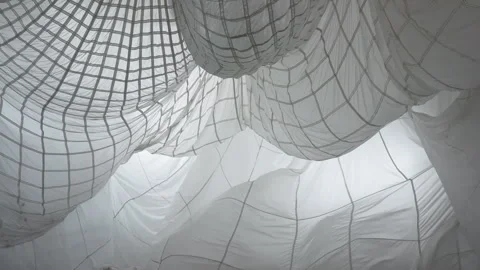 A huge parachute suspended from the ceiling in the pavilion sways in the wind 스톡 동영상 252147481