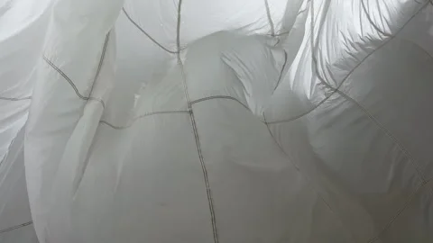 A huge parachute suspended from the ceiling in the pavilion sways in the wind 스톡 동영상 252147702