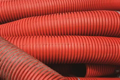 Huge plastic tubes in red lying around Stock Photos