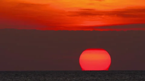 Huge red sun setting over calm sea horizon Stock Footage 335879551