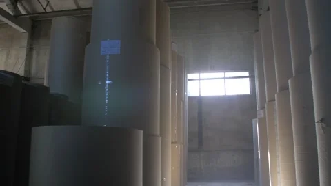 Huge rolls of paper stand in the warehouse for further corrugated box making Stock Footage 233659934