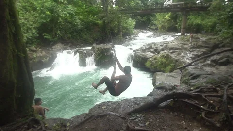 Huge Rope Swing Backflip into Waterfall Pool Stock Footage 87723410