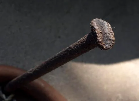 Huge rusty nail driven into the wall Stock Photos