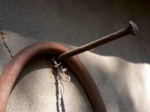 Huge rusty nail driven into the wall Stock Photos