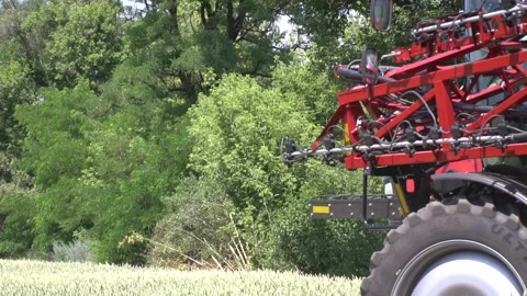 A huge self propelled sprayer is driving on the field on a sunny day Stock Footage 138138588