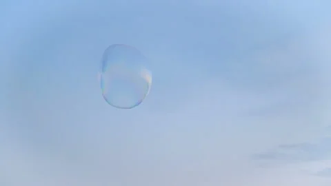 Huge soap bubble hovering in the blue sky Stock Footage 97401078