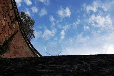 Huge soap bubble rolls down the wall Stock Photos