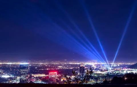 Huge spotlight rays over the night panorama of Los Angeles city Stock Photos