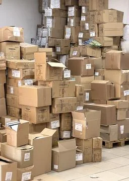 Huge stack of empty old cardboard boxes in store warehouse. Waste, packaging and Stock Photos