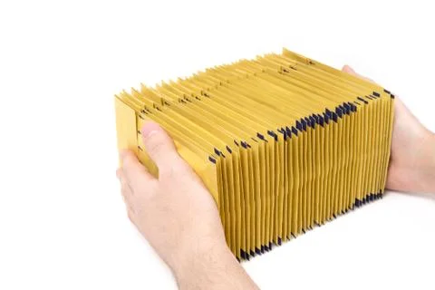 Huge stack of yellow padded envelopes in male hands on a white background. Foto stock