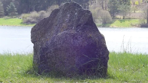 Huge stone on the grass against the river background Stock Footage 74314039
