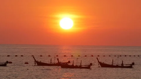 Huge sunset over ocean, long tail fishing boat mooring in sea, moving wave wa Stock Footage 128314683