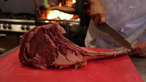 Huge T-bone meat stake, chief cleans the bone from fat before cooking. Stock Footage 202021386