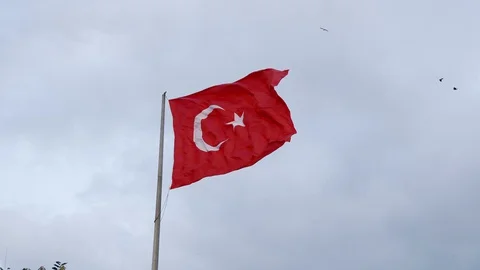 Huge Turkish flag flies on the background of gray clouds	 Stock Footage 127944364