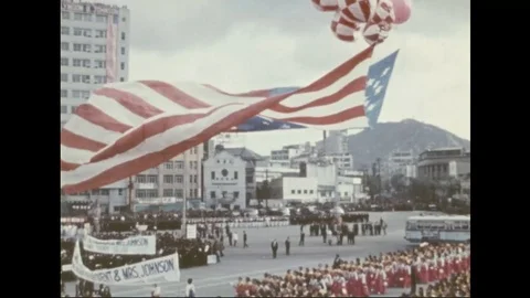 Huge US flag held by balloons during arrival of President and Mrs. Johnson- 1966 Stock Footage 97898938
