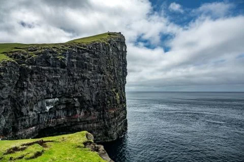 Huge vertical cliffs over the ocean with tourists Foto stock