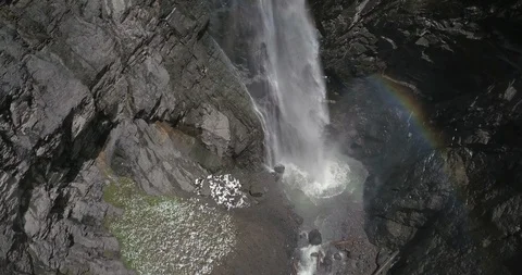 Huge waterfall with rainbow at the bottom pool.  Camera tilts up to view all Stock Footage 111352838