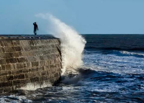 Huge wave breaks over The Cobb Stock Photos