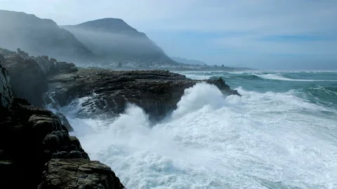 Huge wave making a big splash as it crashes into rocks on rocky coastline, Stock Footage 158086080