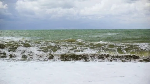 A huge wave rolls over a pebble beach slow mo Stock Footage 81967791