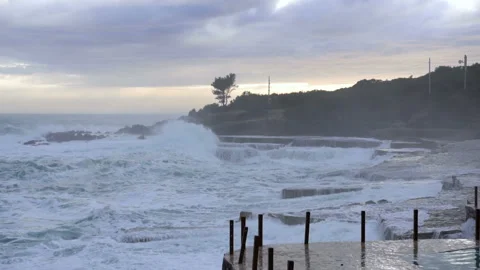 Huge waves break on the stone coast, slow motion 库存影片 102589077