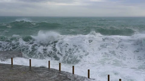 Huge waves break on the stone coast, slow motion Stock Footage 102596356