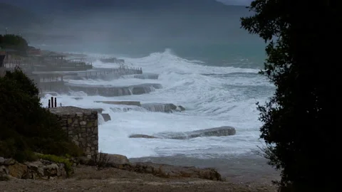 Huge waves break on the stone coast, slow motion Stock Footage 102607877