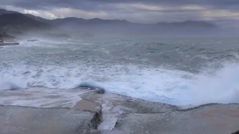 Huge waves break on the stone coast, slow motion Stock Footage 102818610