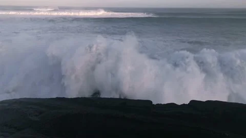 Huge waves crashing against the rocks and releasing large amounts of white fo Stock Footage 142306830