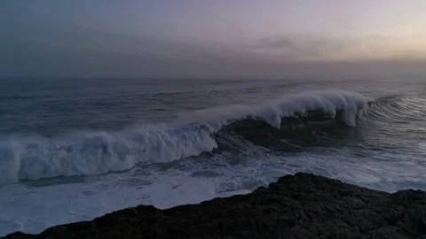 Huge waves with massive force crashing against the rocks at sunrise Stock Footage 142307152