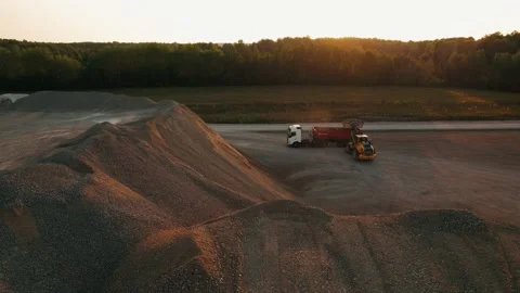 Huge wheel loader with bucket in front load stone in dump truck. Heavy machinery Stock Footage 237499212