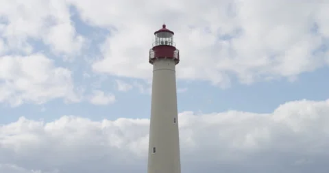 A huge white lighthouse on a cloudy sky background Stock Footage 144986137