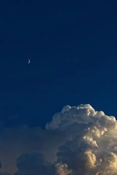 Huge white storm cloud forming with the moon in the sky. Stock Photos