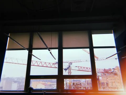 A huge window with two crane behind it Stock Photos