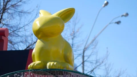 Huge yellow Happy Easter rabbit on the street background Stock Footage 88296051