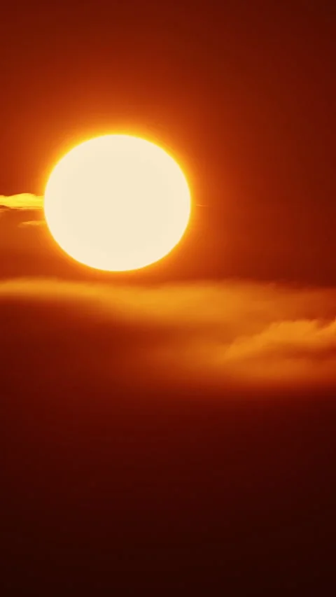 A huge yellow round sun sets behind dark tense clouds Stock Footage 330154664