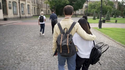Hugging couple of students walking through park Stock-Footage 163283138