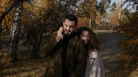 Hugging couple walking in park Видео 81348332