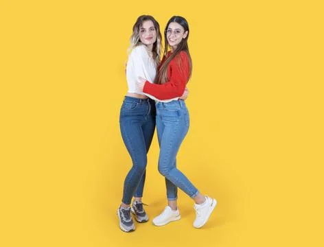 Hugging friends, full body length two caucasian 20s women posing 写真素材