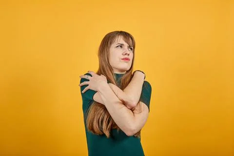 Hugging herself to warm while feeling cold arms crossed fear expression on face Stock Photos