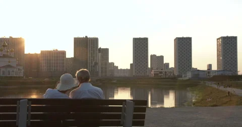 Hugs of an elderly couple sitting on a bench Stock Footage 135580375